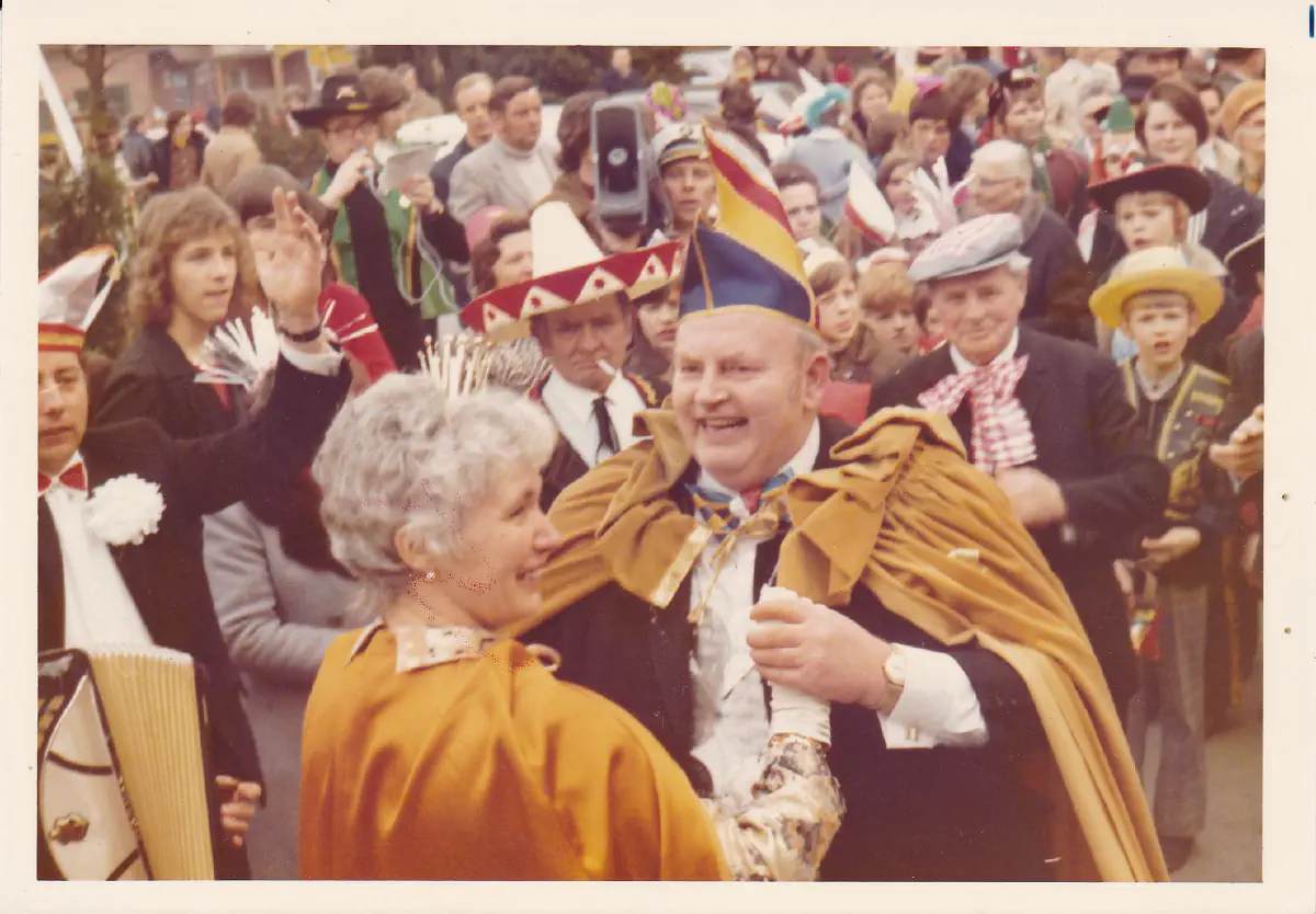 Prinzenpaar in goldenen Mänteln tanzt freudig im Zug